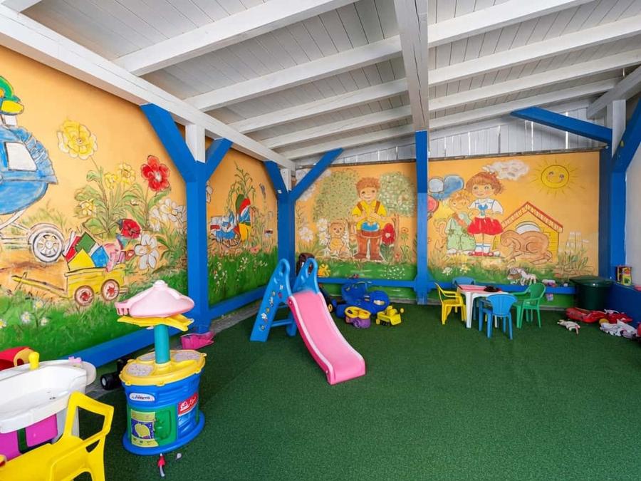 Überdachter Kinderspielplatz der Taverna Metaxa mit Rutsche und Spielzeug